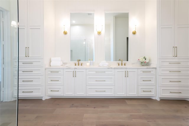 426 81st St, Galveston, TX 77554 - bathroom with double vanity, wood finished floors, a shower stall, and a sink