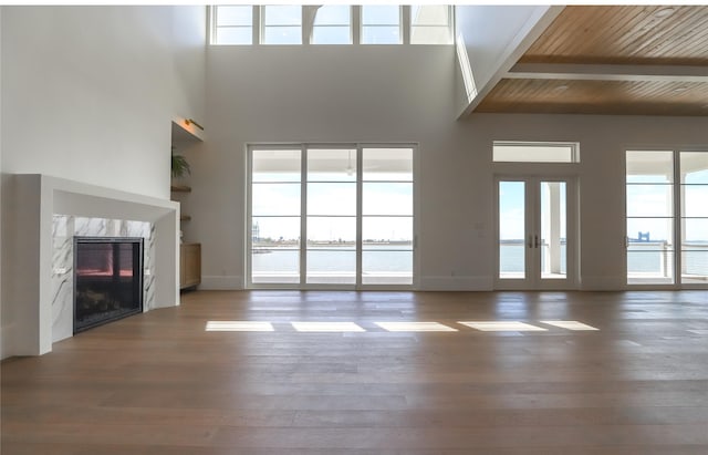 426 81st St, Galveston, TX 77554 - unfurnished living room featuring a towering ceiling, wood finished floors, and a fireplace