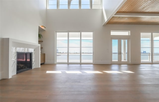 426 81st St, Galveston, TX 77554 - unfurnished living room with beam ceiling, a towering ceiling, wood finished floors, and a wealth of natural light
