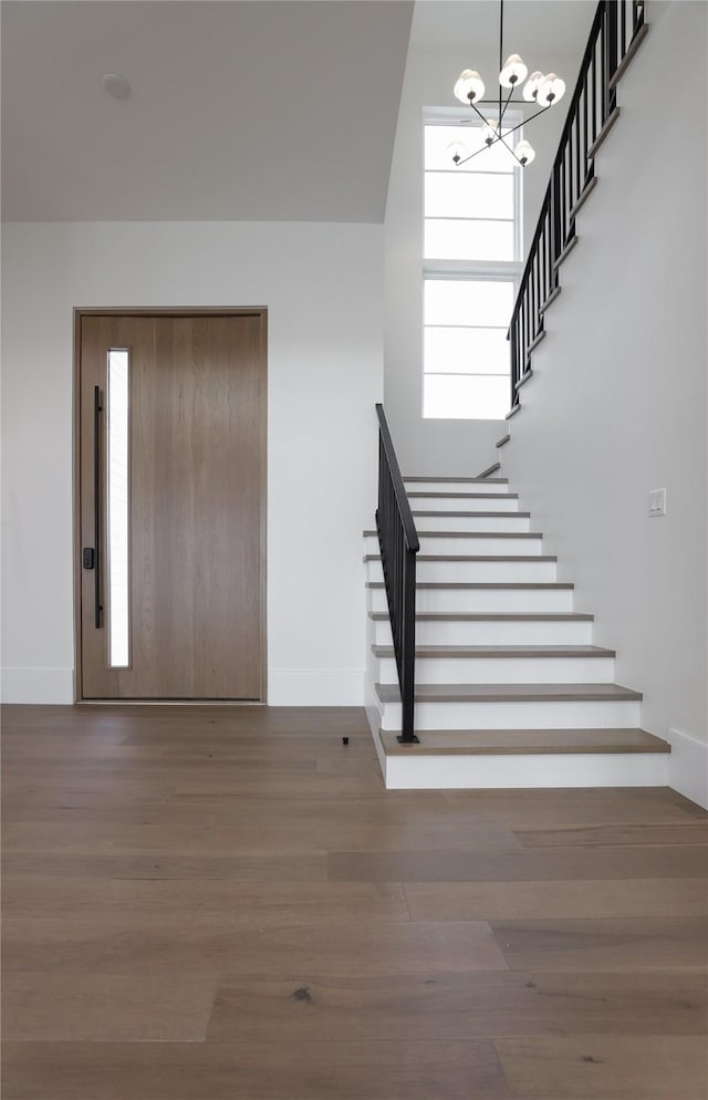 426 81st St, Galveston, TX 77554 - entryway featuring wood finished floors, plenty of natural light, baseboards, stairway, and a notable chandelier