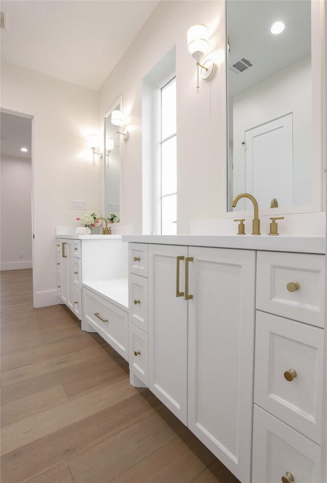 426 81st St, Galveston, TX 77554 - bathroom featuring vanity, recessed lighting, visible vents, and wood finished floors