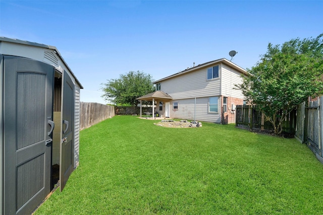 rear view of property with a gazebo, a yard, and a fenced backyard