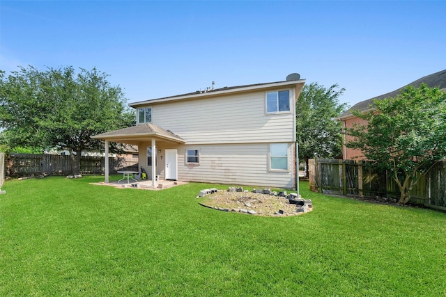 rear view of house featuring a patio, a fenced backyard, and a lawn
