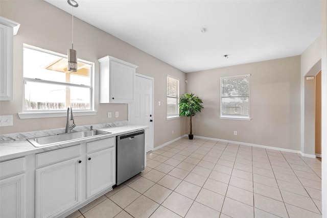 kitchen with light tile patterned floors, light countertops, dishwasher, a sink, and white cabinetry