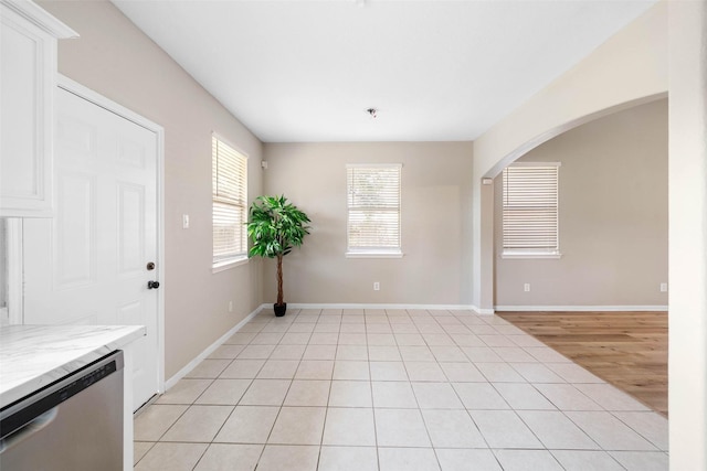 interior space with baseboards and arched walkways