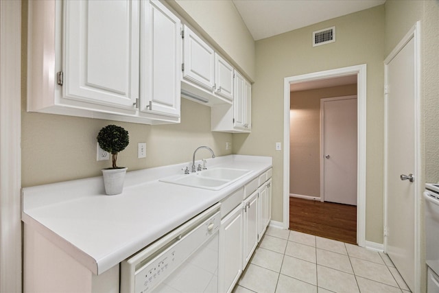 washroom with light tile patterned floors, a sink, baseboards, and visible vents