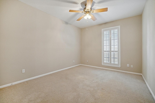 spare room with carpet flooring, ceiling fan, and baseboards