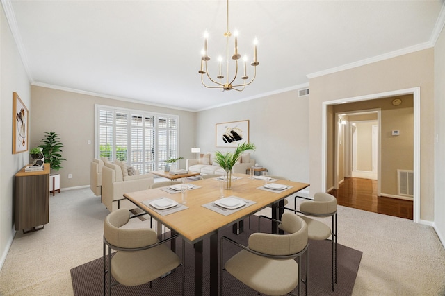dining space featuring visible vents, an inviting chandelier, crown molding, and light colored carpet
