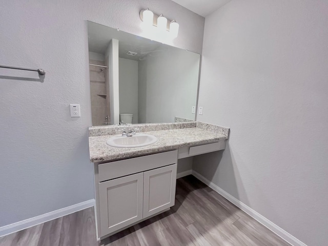 312 N Orange St, Sweeny, TX 77480 - bathroom featuring wood finished floors, vanity, baseboards, and a shower