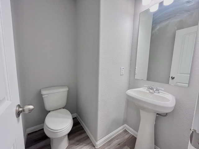 312 N Orange St, Sweeny, TX 77480 - bathroom featuring wood finished floors, toilet, and baseboards