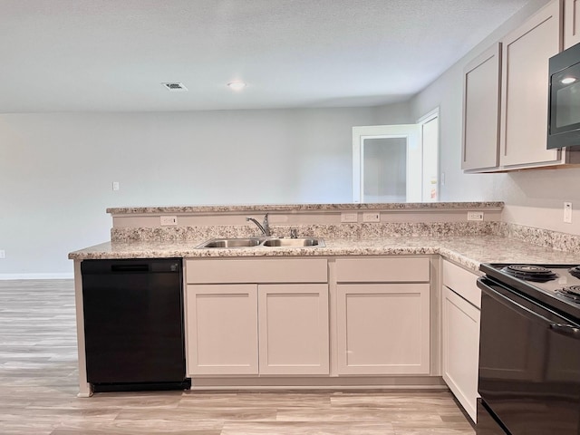 312 N Orange St, Sweeny, TX 77480 - kitchen featuring black appliances, a sink, light wood finished floors, and light stone countertops