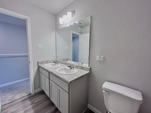 312 N Orange St, Sweeny, TX 77480 - bathroom with wood finished floors, toilet, double vanity, and baseboards