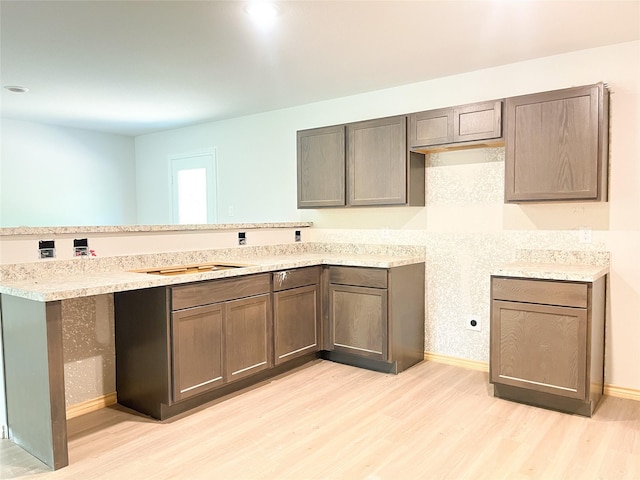 312 N Orange St, Sweeny, TX 77480 - kitchen featuring light wood-style flooring, a peninsula, and baseboards
