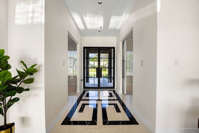 entryway with baseboards and marble finish floor