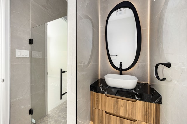 bathroom featuring tile walls and vanity