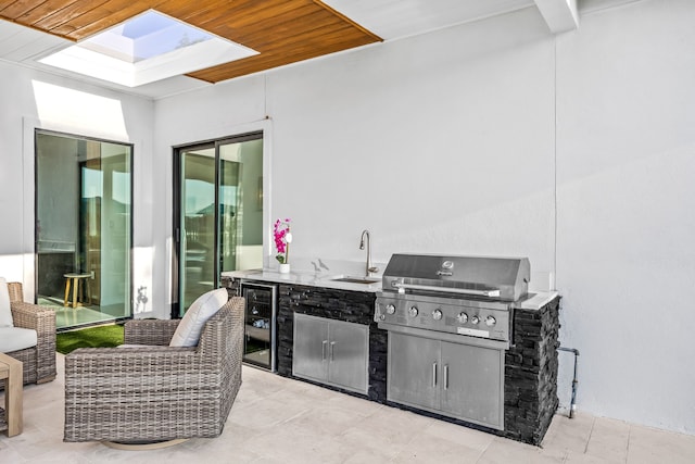 view of patio / terrace with a sink, an outdoor kitchen, grilling area, and wine cooler