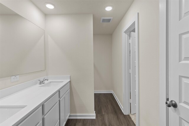 457 Shoreview Dr, Conroe, TX 77303 - bathroom featuring wood finished floors, double vanity, a sink, baseboards, and visible vents
