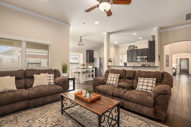 living room with crown molding, arched walkways, wood-type flooring, and a ceiling fan