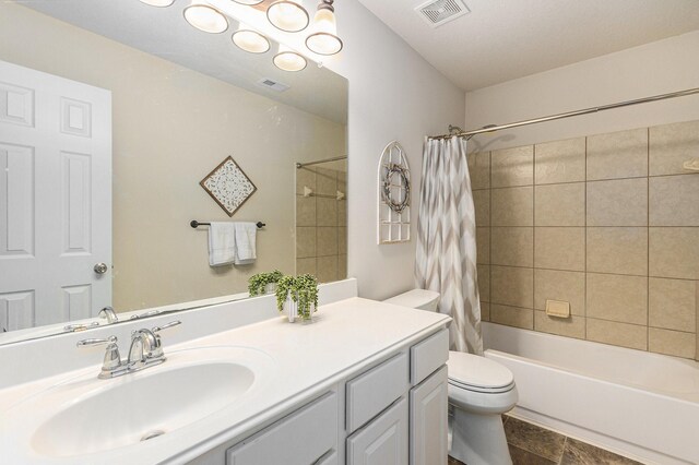 bathroom featuring visible vents, shower / bath combo with shower curtain, toilet, and vanity