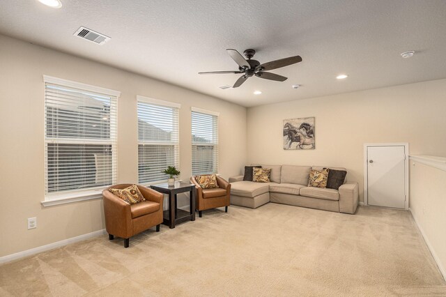 living room with visible vents, baseboards, ceiling fan, light colored carpet, and recessed lighting