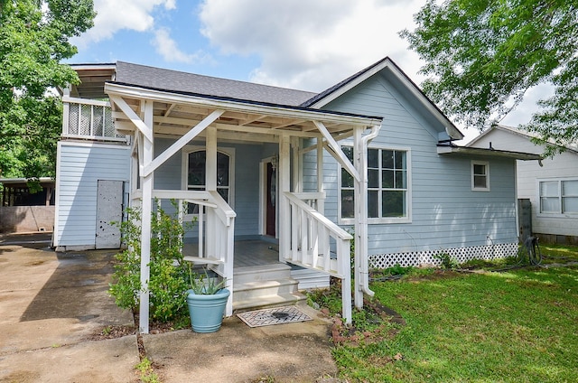 view of front of property featuring a front yard and a shingled roof