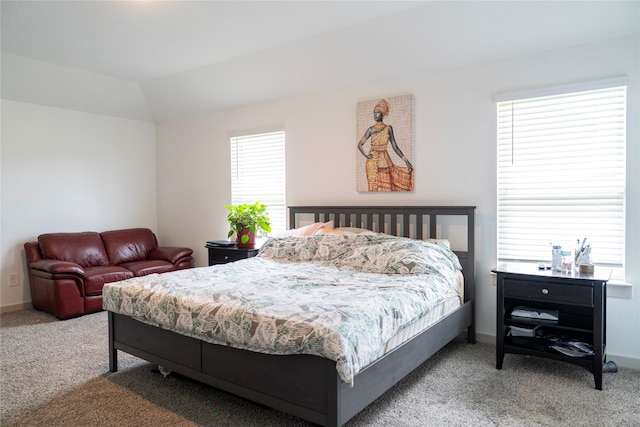 carpeted bedroom featuring lofted ceiling and baseboards