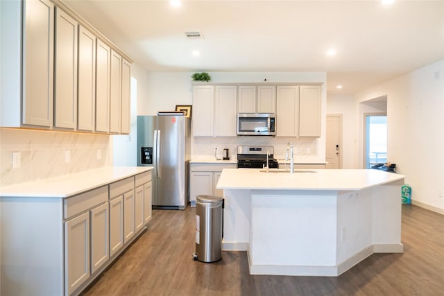 kitchen with decorative backsplash, appliances with stainless steel finishes, light wood finished floors, a sink, and visible vents