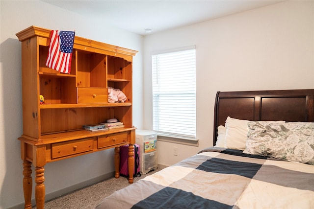 carpeted bedroom featuring baseboards and multiple windows