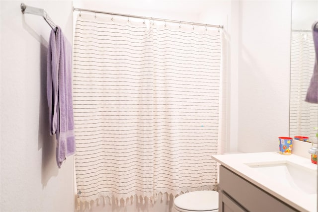 full bathroom featuring toilet, vanity, and a shower with curtain