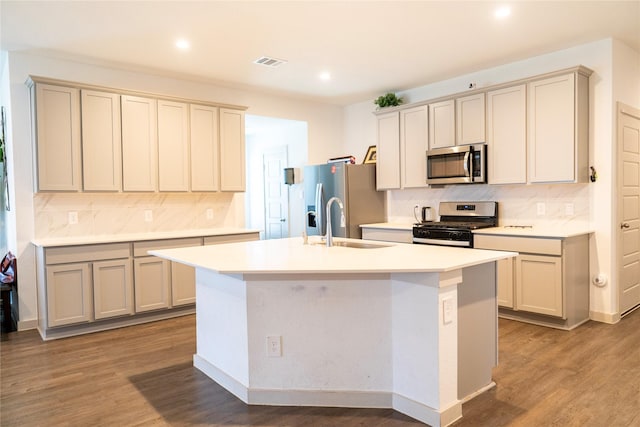 kitchen featuring recessed lighting, stainless steel appliances, backsplash, and a kitchen island with sink