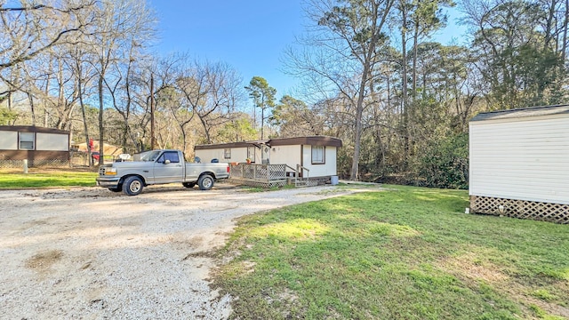 view of yard featuring dirt driveway and an outbuilding