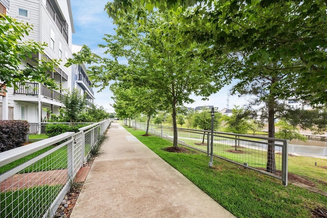 view of property's community with a yard and fence