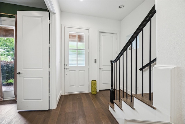 foyer with dark wood-type flooring, recessed lighting, and stairway