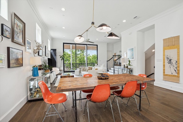 dining space featuring crown molding, stairway, wood finished floors, and baseboards