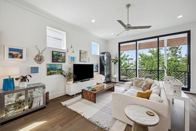living area with wood finished floors, crown molding, a ceiling fan, and baseboards