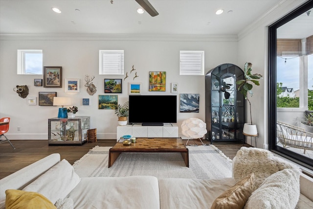 living room with baseboards, wood finished floors, a ceiling fan, and crown molding