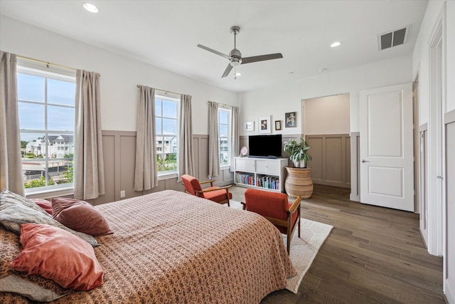 bedroom with recessed lighting, wood finished floors, a decorative wall, a wainscoted wall, and visible vents