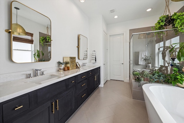 bathroom with visible vents, a stall shower, a freestanding bath, and a sink