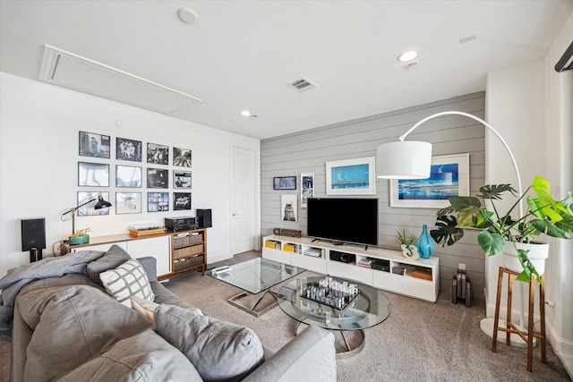 carpeted living area featuring wooden walls, attic access, visible vents, and recessed lighting