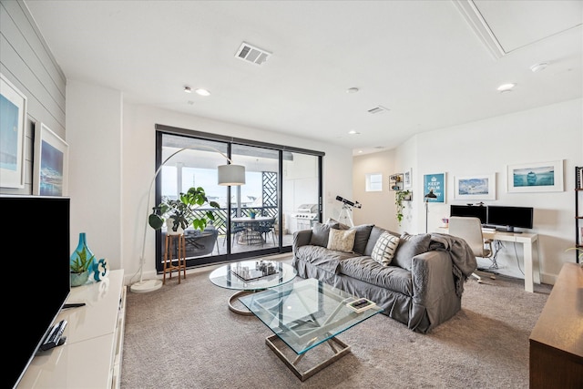 carpeted living area with attic access, recessed lighting, and visible vents