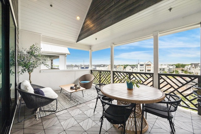 sunroom with lofted ceiling and a residential view