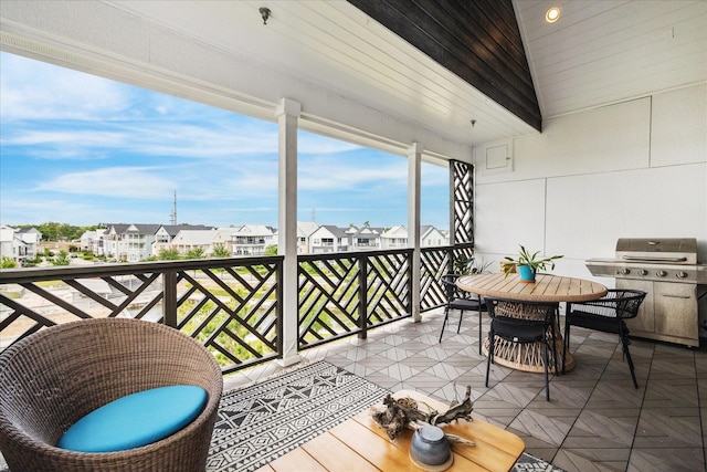 balcony featuring outdoor dining space, grilling area, and a residential view