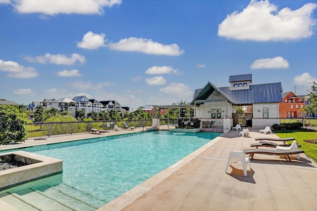community pool with a residential view, a patio, and fence