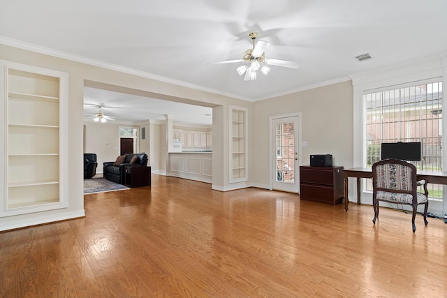 interior space with light wood-type flooring, visible vents, built in shelves, and a ceiling fan