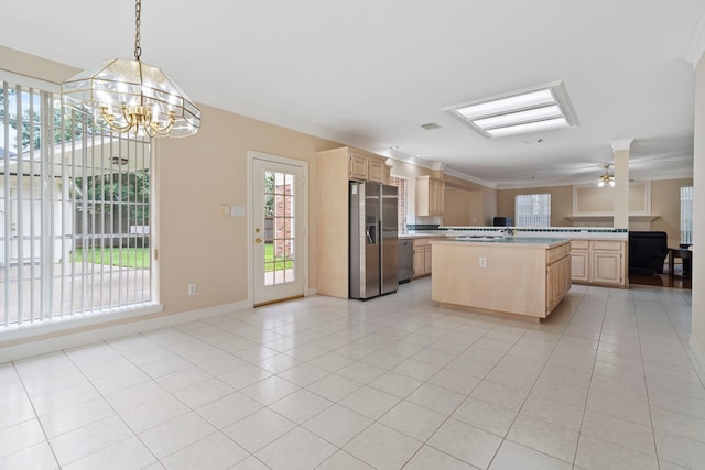 kitchen featuring light brown cabinetry, light countertops, ornamental molding, stainless steel refrigerator with ice dispenser, and open floor plan