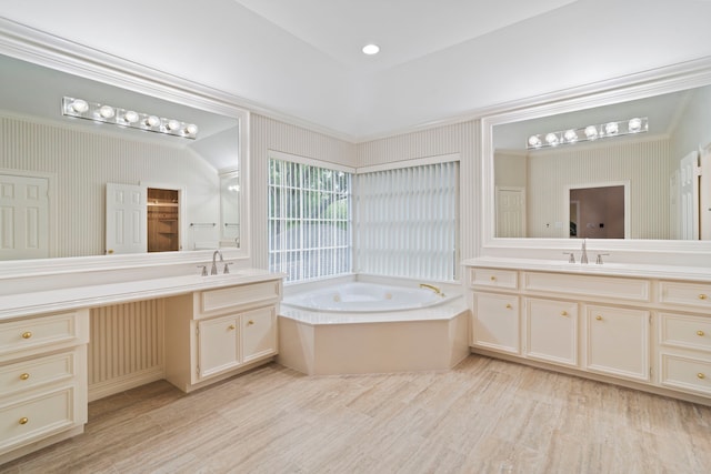 bathroom with a garden tub, two vanities, and a sink