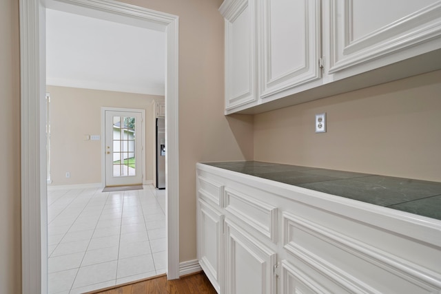interior space featuring light tile patterned flooring and baseboards