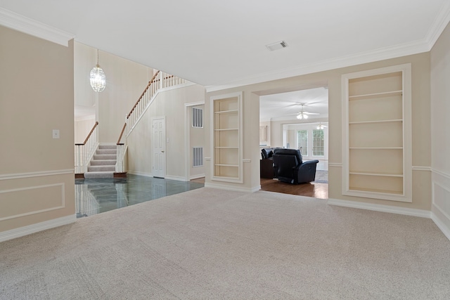 unfurnished living room with crown molding, visible vents, carpet, built in features, and stairs