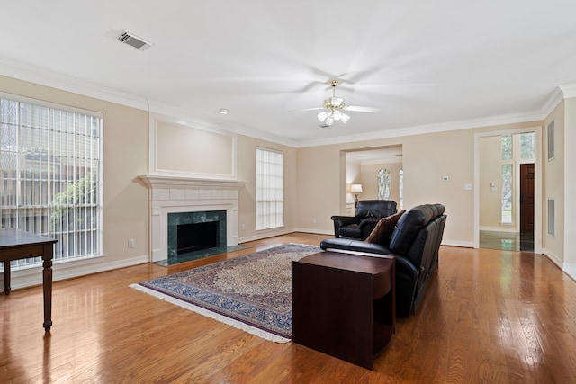 living area featuring crown molding, a ceiling fan, wood finished floors, and baseboards