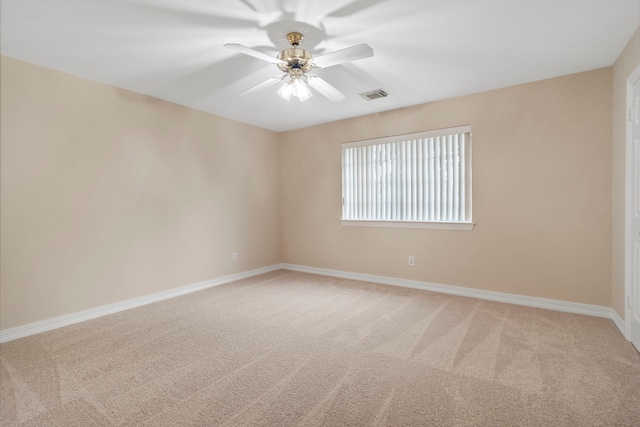 spare room with visible vents, baseboards, a ceiling fan, and light carpet